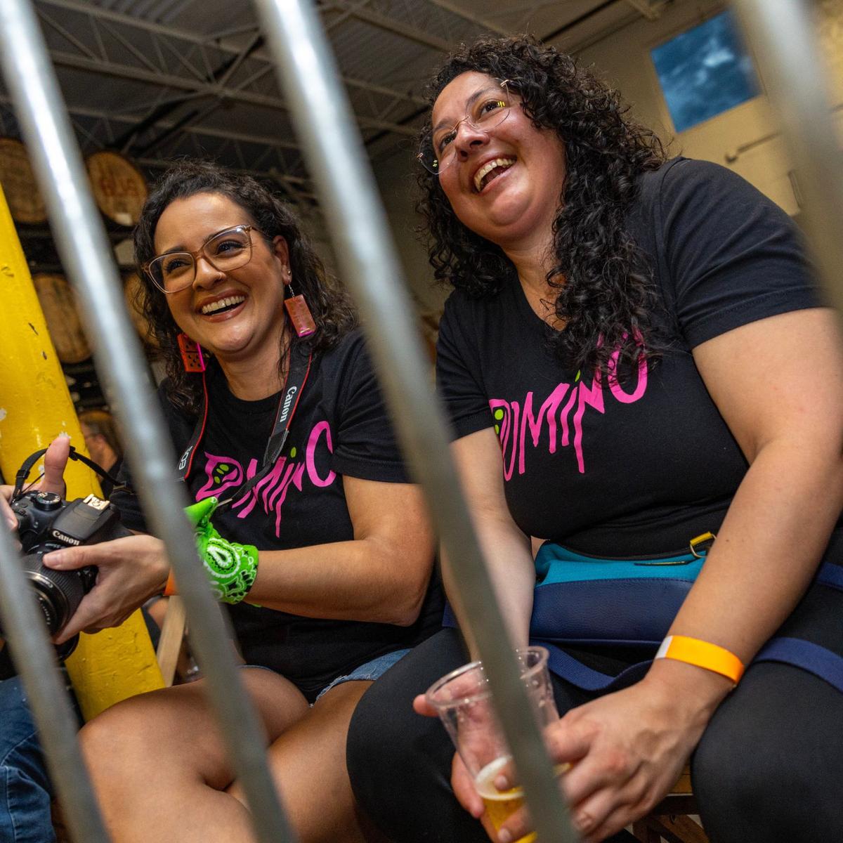 Domino fans Laura Garciga, left, and Ana Maria Garciga, right, cheer at the Bash at the Brew.
