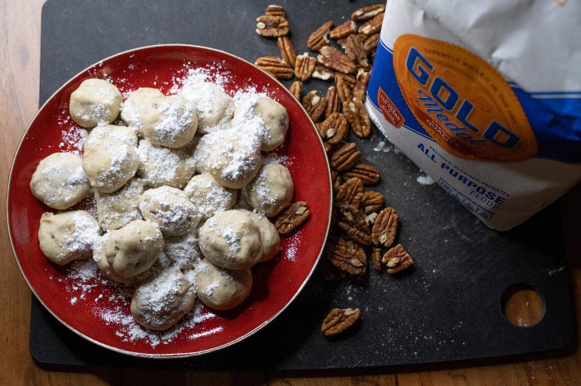 Mexican Wedding Cookies, photographed from above, next to pecans and all purpose flour.