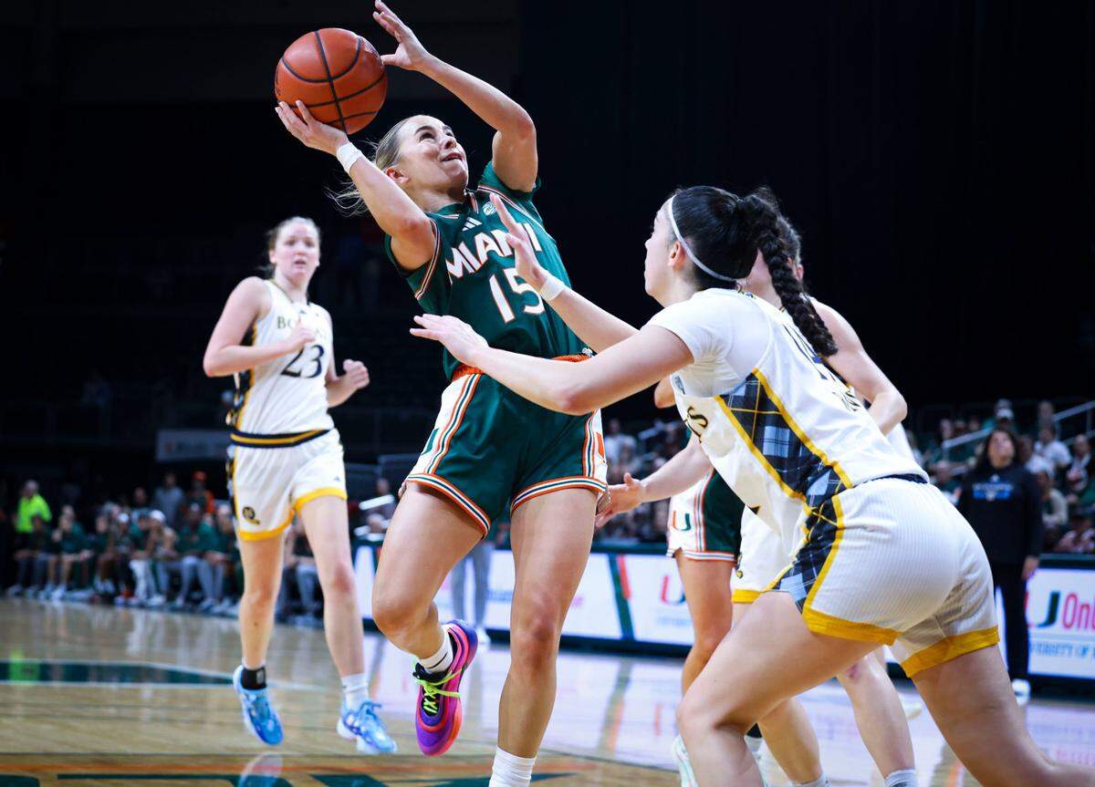 Miami Hurricanes Hanna Cavinder(15) shoots the ball over Quinnipiac Bobcats Gal Raviv (14) during the second quarter of the game on Sunday, Dec. 1, 2024, at Watsco Center in Coral Gables, Fla. 