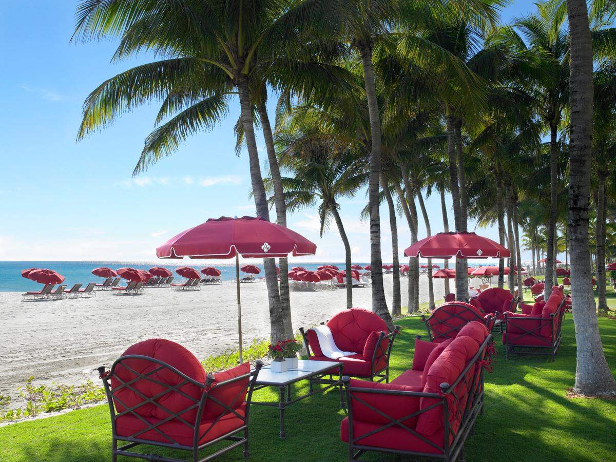 The iconic red couches, chairs and umbrellas at the beachfront Acqualina Resort in Sunny Isles Beach.