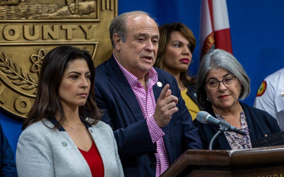 Flanked by Miami-Dade County Mayor Daniella Levine Cava, right, and Doral Mayor Christi Fraga, left, Miami-Dade County Commissioner J.C Bermudez, speaks to reporters during a press conference at the Miami-Dade County Emergency Operations Center.