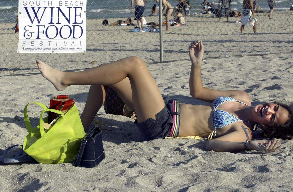  In 2004, Monica Fernandez,  12, of Miami enjoys a laugh  and a rest from a day spent scarfingd own exotic  food and drinks at the South Beach Wine & Food Festival Grand Tasting.