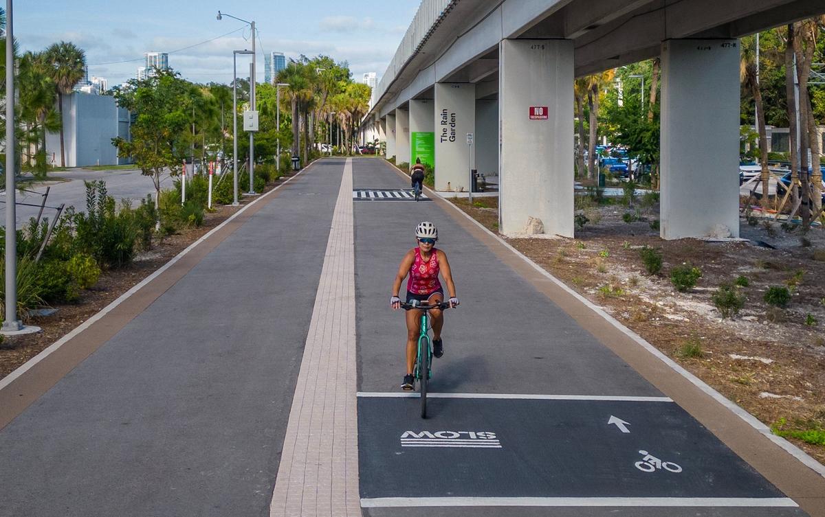 Cyclists ride past the Rain Garden at Southwest 17th Avenue and U.S. 1 along a new, two-mile section of The Underline urban trail and linear park that opens April 24.