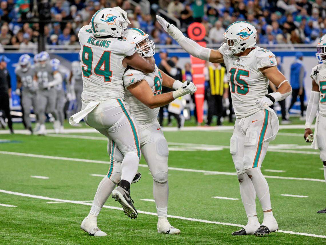 Miami Dolphins defensive tackle Zach Sieler (92) defensive tackle Christian Wilkins (94) and linebacker Jaelan Phillips (15) celebrate after Sieler sacks Detroit Lions quarterback Jared Goff (16) in the third quarter at Ford Field in Detroit, Michigan on Sunday, October 30, 2022.