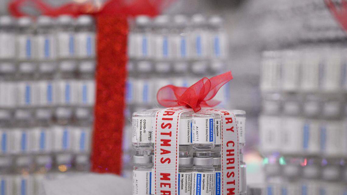 Present boxes made of COVID-19 vaccines are placed next to a Christmas tree made of empty vaccine containers at a vaccination center in Bucharest, Romania, Monday, Dec. 6, 2021.