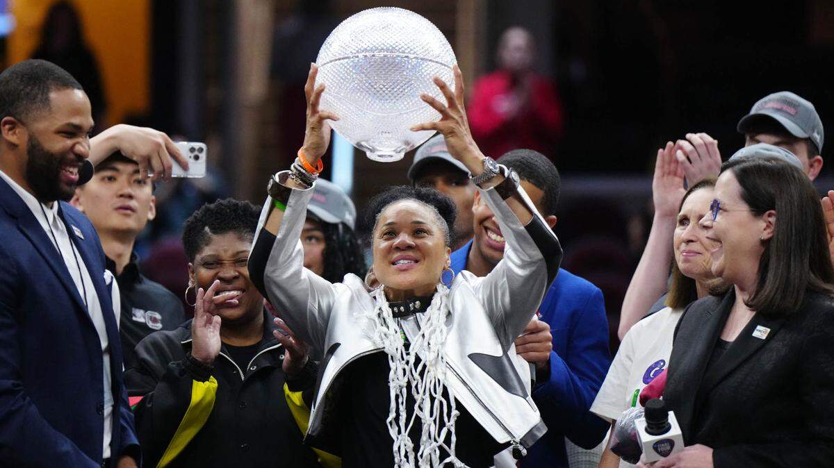 South Carolina Gamecocks head coach Dawn Staley celebrates with the WBCA coaches trophy after defeating the Iowa Hawkeyes in the finals of the Final Four of the womens 2024 NCAA Tournament at Rocket Mortgage FieldHouse.