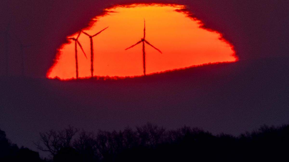 Wind turbines in front of the rising sun in Frankfurt, Germany in March.