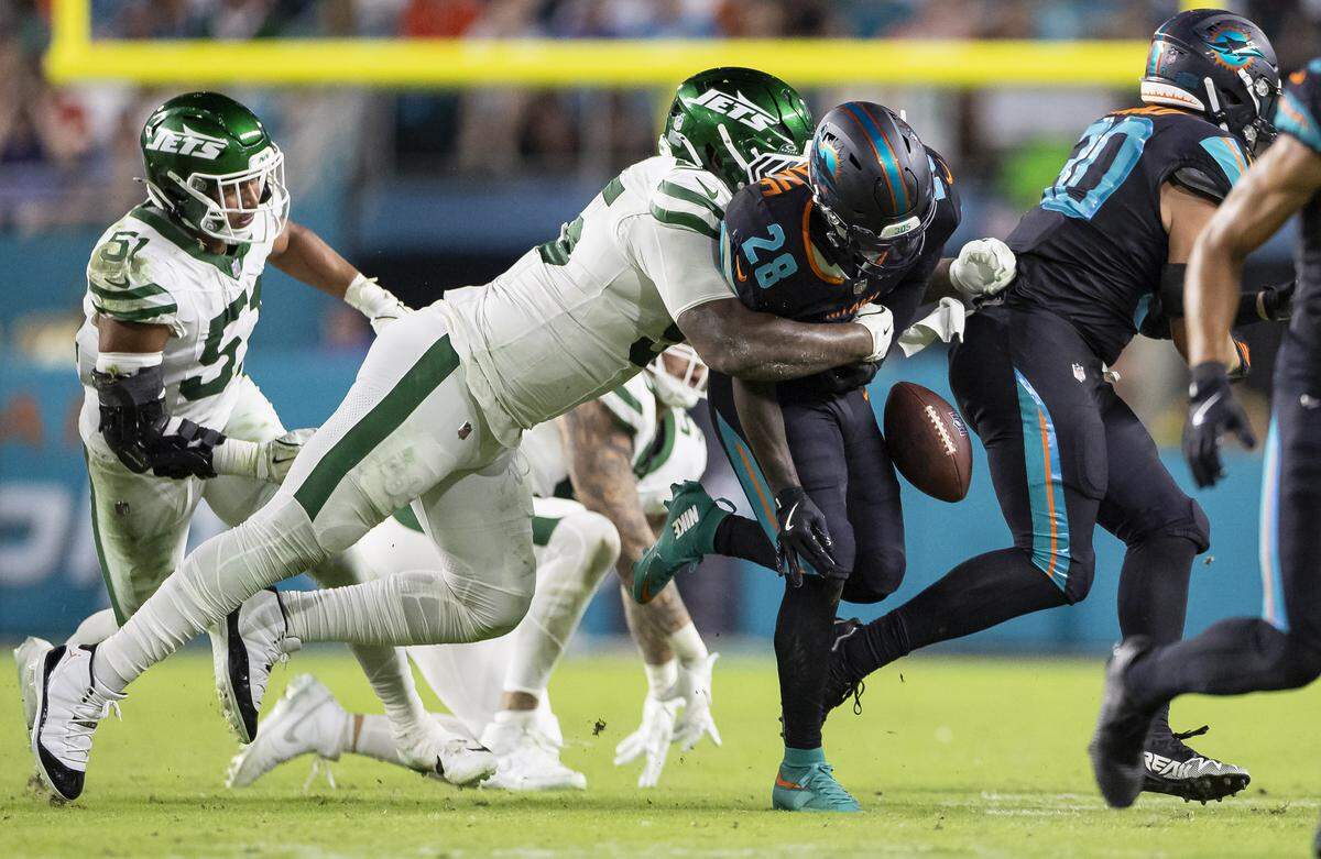 New York Jets defensive tackle Quinnen Williams (95) forces Miami Dolphins running back de'von Achane (28) to fumble the ball in the second half of their NFL game at Hard Rock Stadium on Monday, Sept. 29, 2025, in Miami Gardens, Fla.