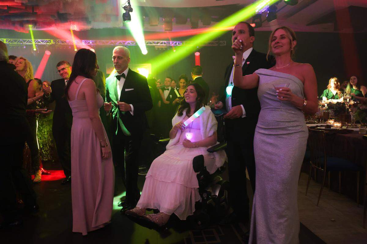 Boating accident survivor Katerina “Katy” Puig, center, enjoys the dance floor with her family during the Nicklaus Children's Foundation Diamond Ball at the JW Marriott Marquis in Downtown Miami, Saturday, October 18, 2025.