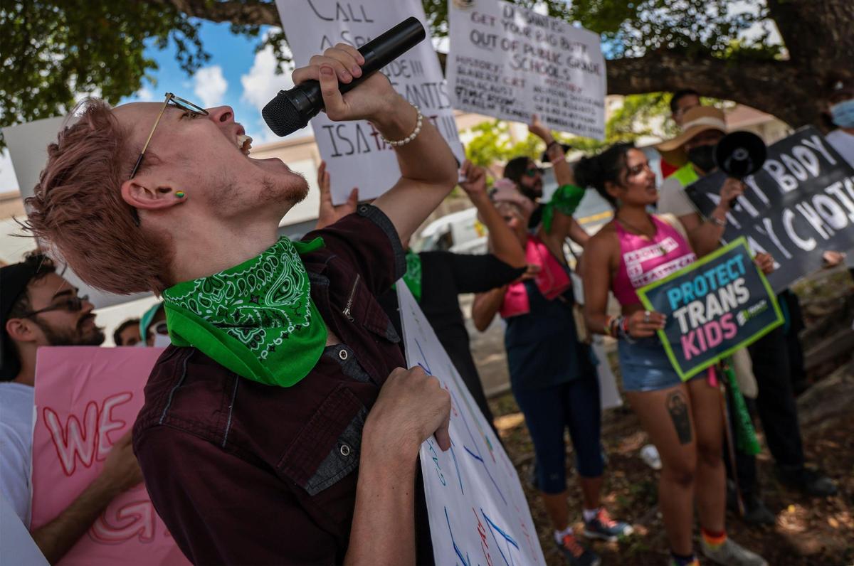Maxx Fenning, left, founder of the LGTBQ non-profit PRIZM, leads protesters in anti-DeSantis chants. On Sunday, August 21, 2022, protesters gathered outside the Metro-Dade Firefighters Local 1403 in Doral, Florida, as Gov. Ron DeSantis spoke at an event for pro-DeSantis school board candidates.