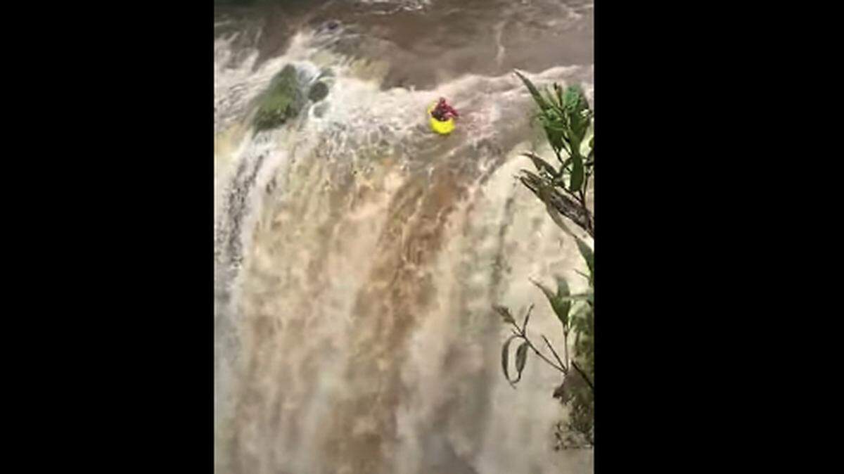 A screen grab of a video showing two kayakers plunge off a 98-foot waterfall in Dangar Falls in Australia.