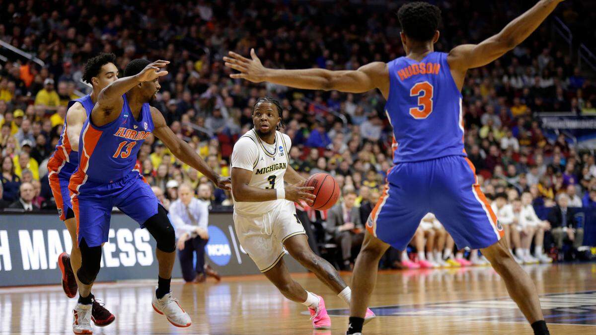 Michigan’s Zavier Simpson (3) drives against Florida’s Andrew Nembhard, left, Kevarrius Hayes (13) and Jalen Hudson (3) during the first half of a second round men’s college basketball game in the NCAA Tournament, in Des Moines, Iowa, Saturday, March 23, 2019.