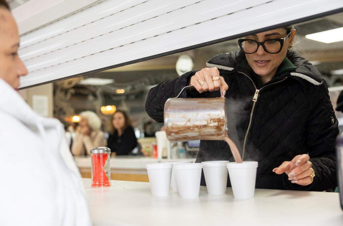 Coffee is served for a customer at Versailles Restaurant Cuban Cuisine as temperatures dip into the mid 40s across South Florida on Friday, Jan. 24, in Miami, Fla.