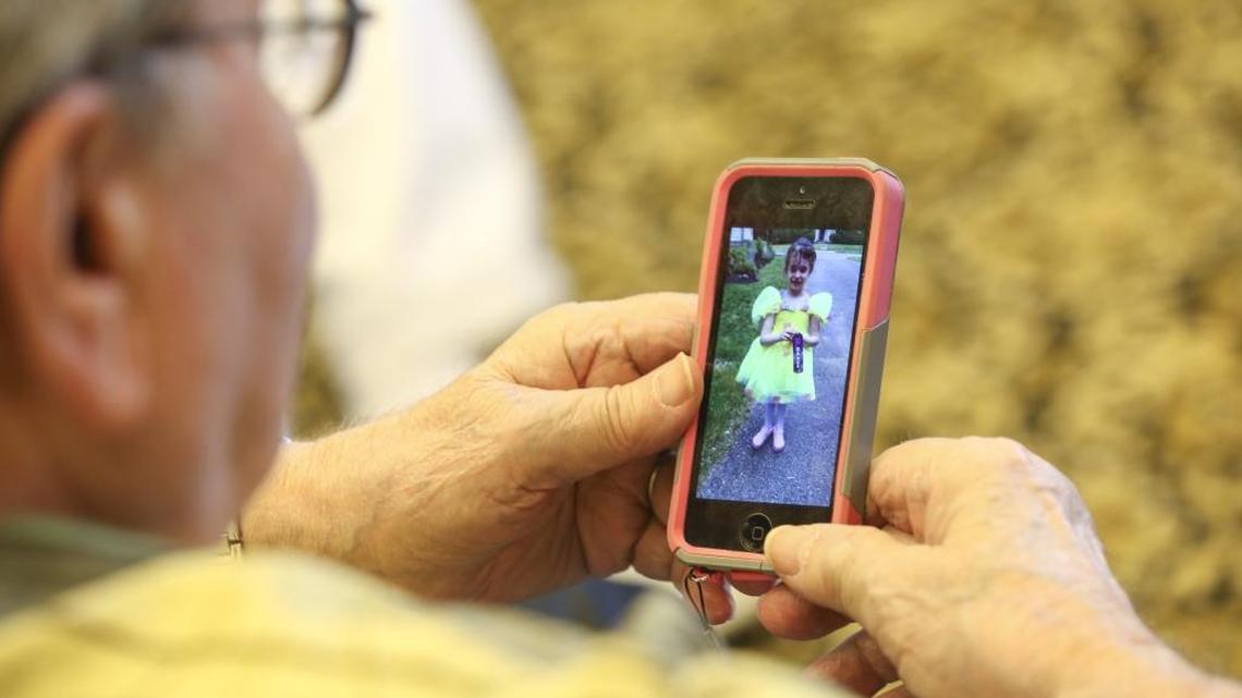Julius Wishnia looks at a photo of his granddaughter, Lily, 4, on his phone during at The Palace, a luxury senior community in Coral Gables, on Saturday, June 11, 2016.
