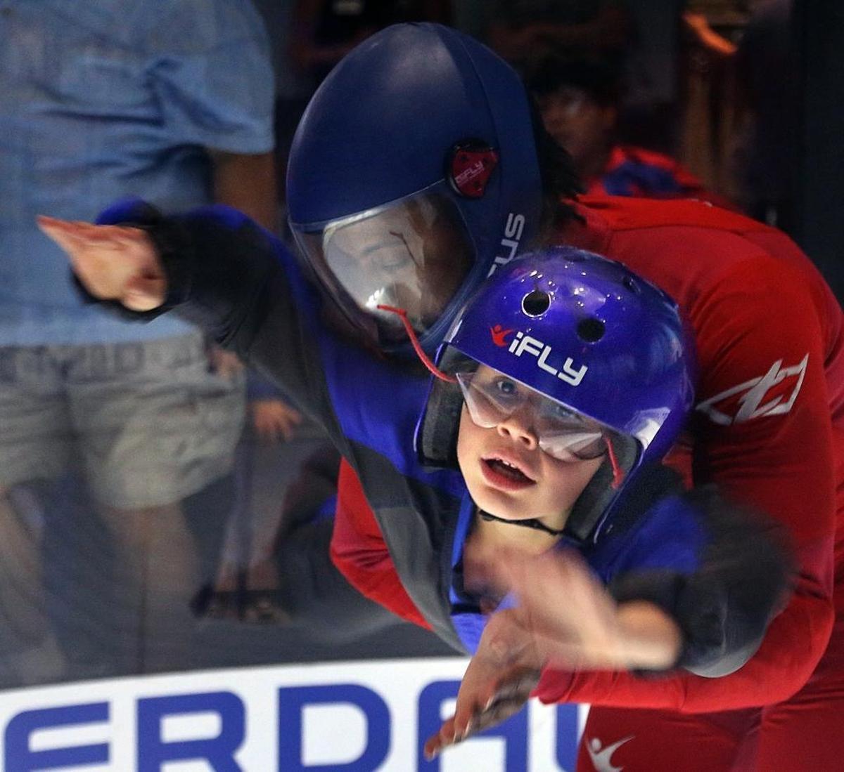 Michaela Sterne, who has autism, is carefully guided into the wind chamber at iFly.