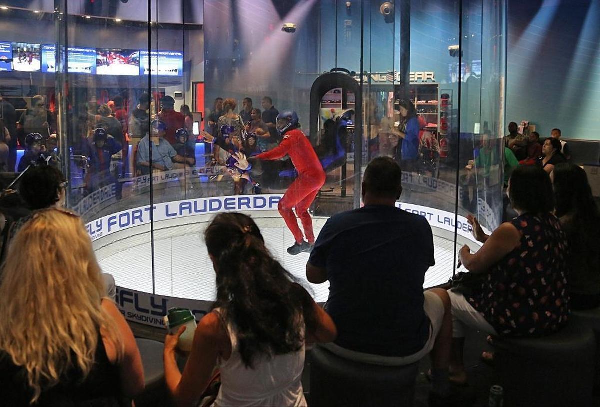 Families and friends gather around the vertical wind tunnel to watch friends and family members try indoor skydiving at iFly’s All Abilities Night.