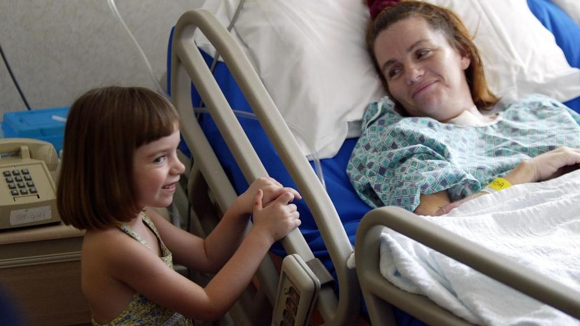 In an August 2003 file photo, Alana Harris, 5, visits her mother, Denise Harris, in recovery at Broward General Medical Center two months after a car crash that left Denise Harris paralyzed from the chest down.