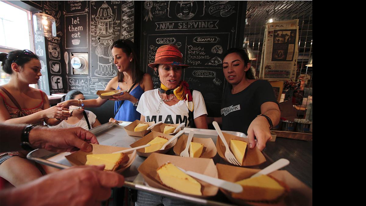 
A TASTE OF WYNWOOD: Tour guide Mirka Harris, center, serves Key lime pie at Fireman Derek’s Bake Shop during a Miami Culinary Tour.
