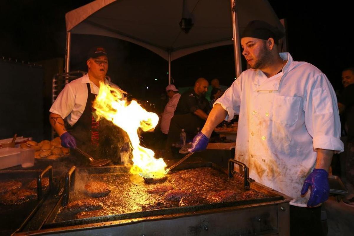 Sandy Rodriguez, 33, right, prepares a Quality Meats' Bacon PB&JJ Burger during Burger Bash at the 2017 South Beach Wine & Food Festival on Friday, Feb. 25, 2017.