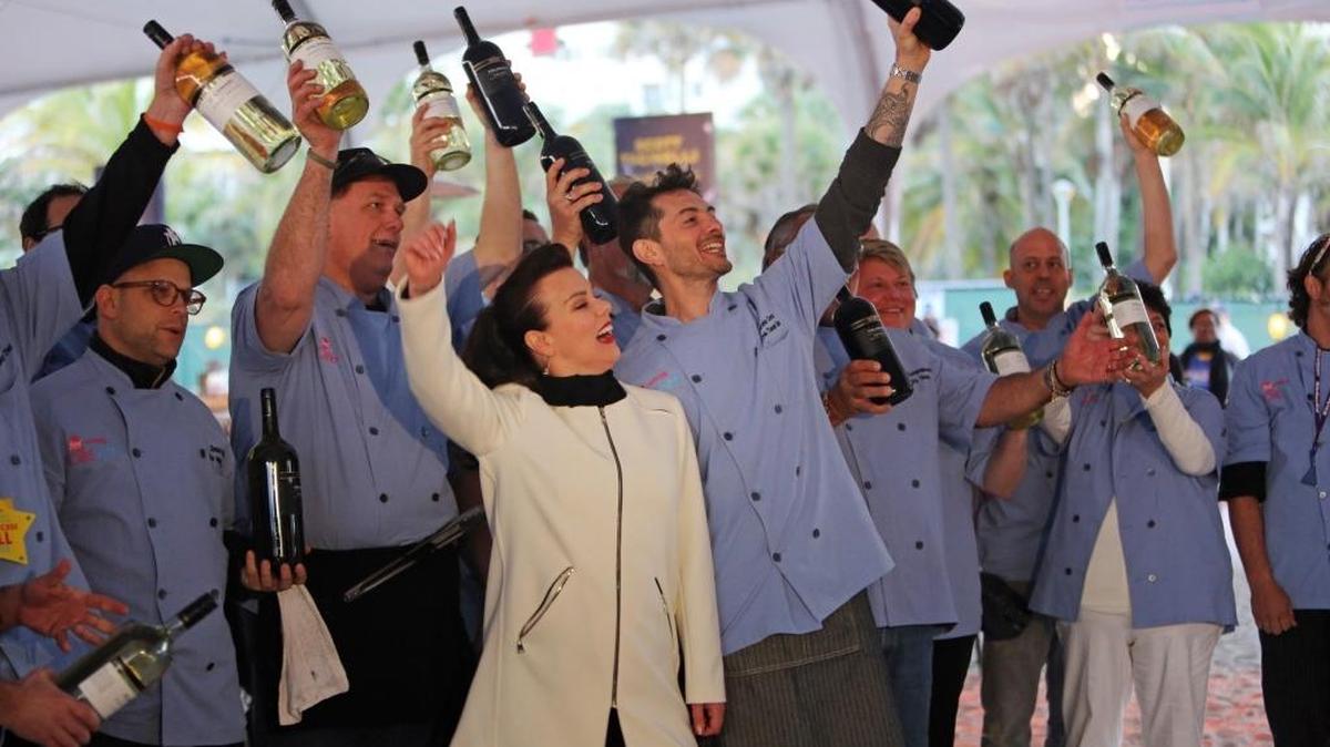 
Salud! Cooking Channel stars Debi Mazar (in white) and her husband, Gabriele Corcos (with arm tattoo), kick off the 2015 South Beach Wine & Food Festival with other chefs at the Al Fresco Italian Feast on the sands of Miami Beach.
