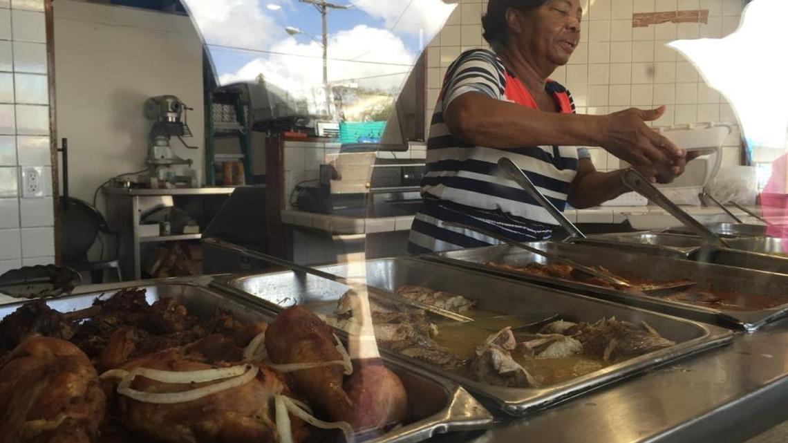 Melisane Craan, a cook at Naomi’s Garden Restaurant & Lounge in Little Haiti, serves food.