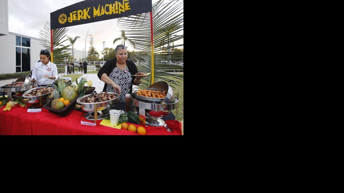 
Taste of Jamaica: Jerk Machine CEO Catherine Malcolm, right, and daughter Diedre Malcolm serve spicy jerk chicken and pork. 
