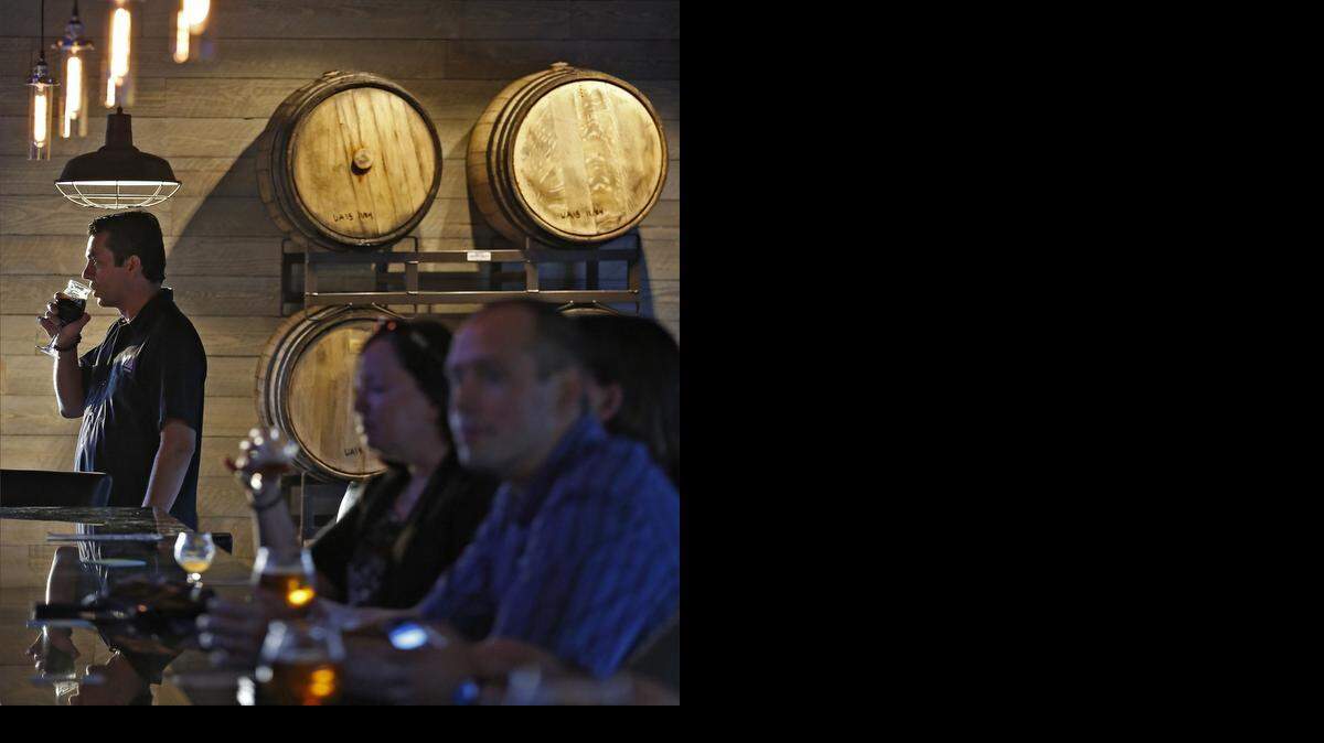 
Bottoms up: M.I.A. Brewing co-owner Eddie Leon, left, drinks a stout in his new brewery’s tasting room in Doral. Below are some of the 15-plus styles on draft at M.I.A. 
