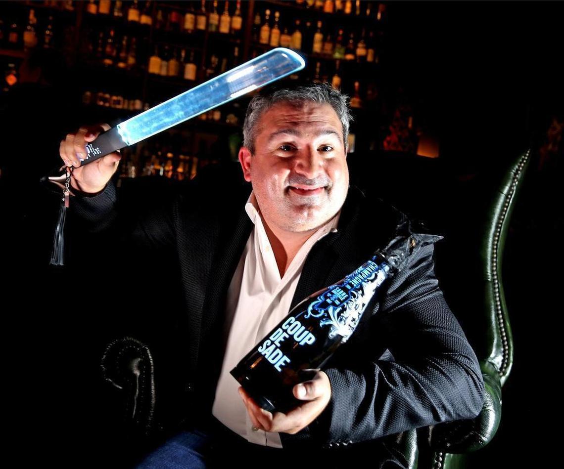 Jean Paul Desrochers is pictured with a bottle of his company’s Coup de Sade, a premium line of champagne that’s engineered to ‘saber’ safely. The bottle is uncorked by hitting it with the object Desrochers has in his right hand.