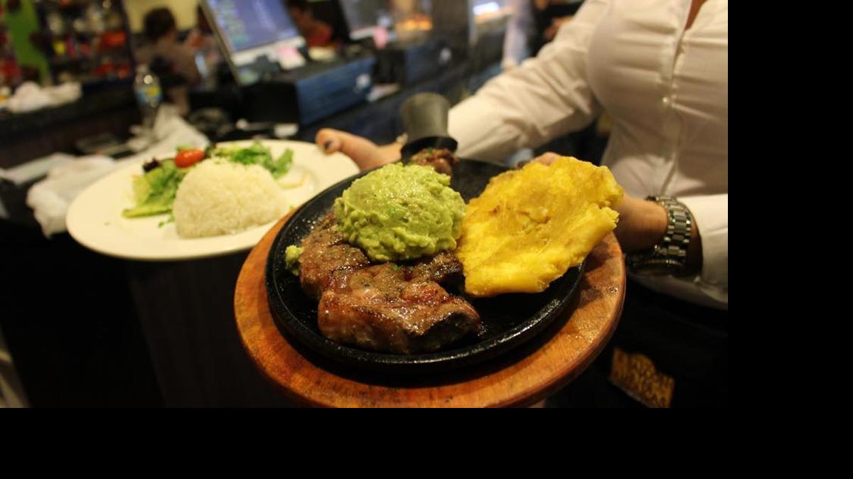
Colombian and more: A server carries plates of food at an El Balcon de las Americas restaurant. 
