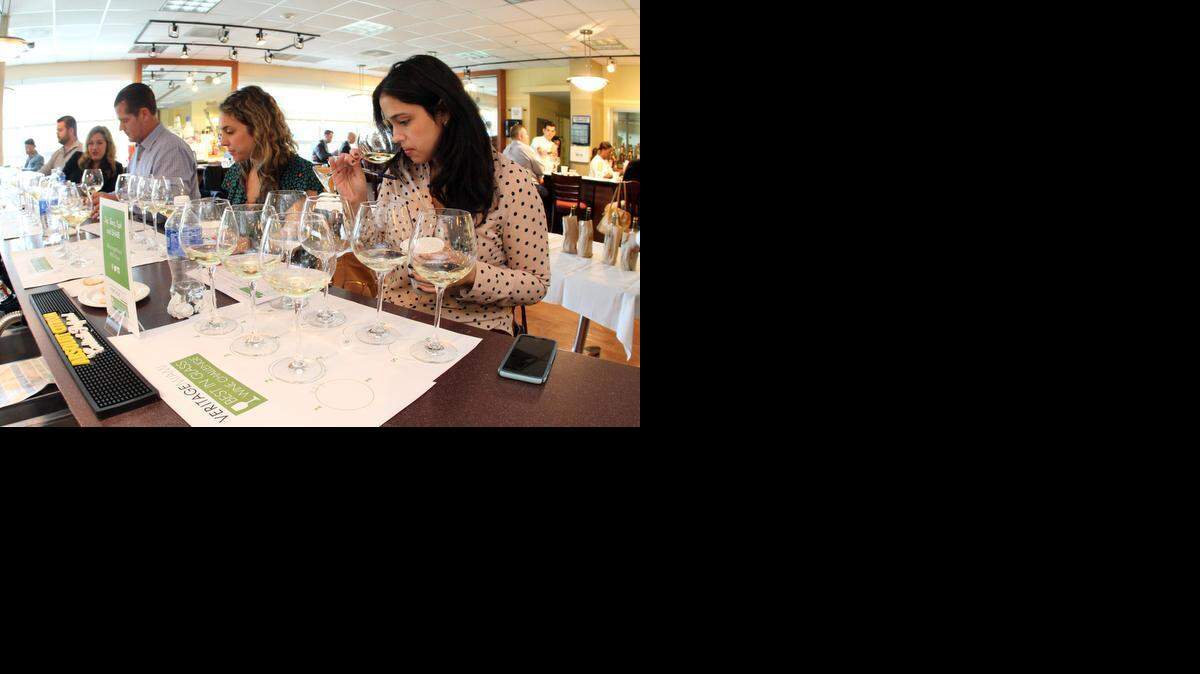 
Swirl, sniff, sip: Amanda Fraga, right, sommelier at Michael’s Genuine Food & Drink in Miami, samples wine during Veritage Miami’s Best in Glass competition at Johnson & Wales University. 
