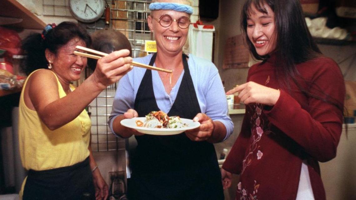 In a 1994 photograph, Hy Vong’s Tung Nguyen (left), Kathy Manning (center) and Nguyen’s daughter, Phuonglien “Lyn” Nguyen, share a laugh over a plate of Vietnamese food from their restaurant in Miami’s Little Havana.