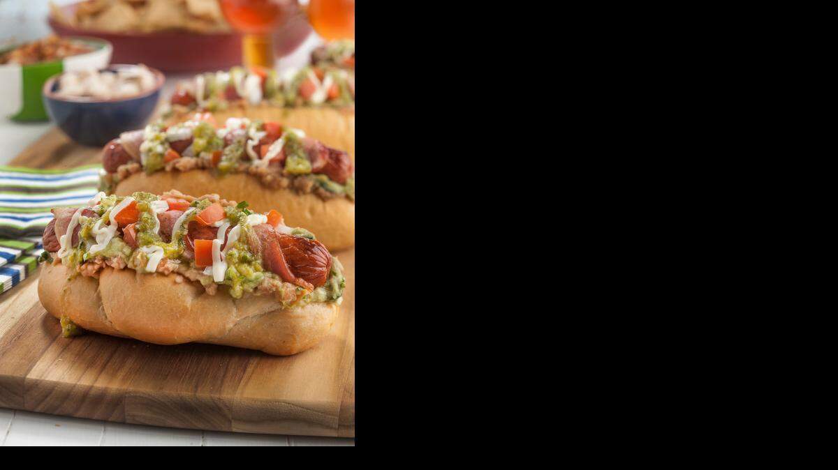 
Sonoran hot dog: Built with bacon, guacamole, refried beans, cheese, onion, tomato, salsa and mayo. 
