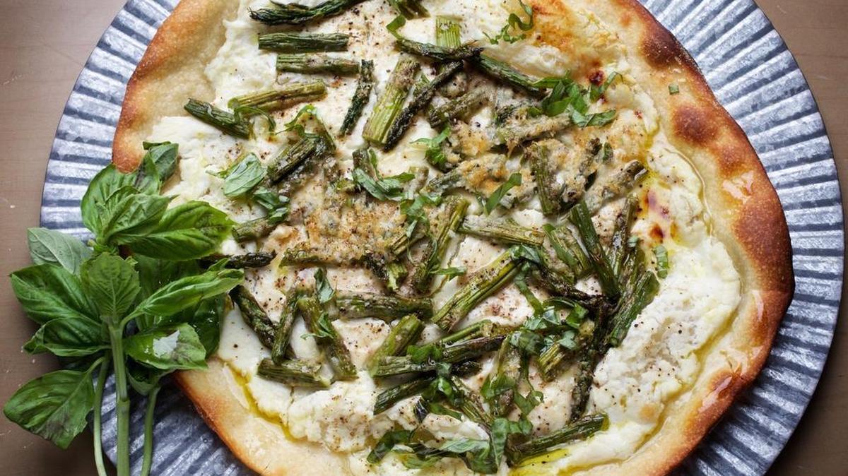 Pizza with asparagus, ricotta and basil.