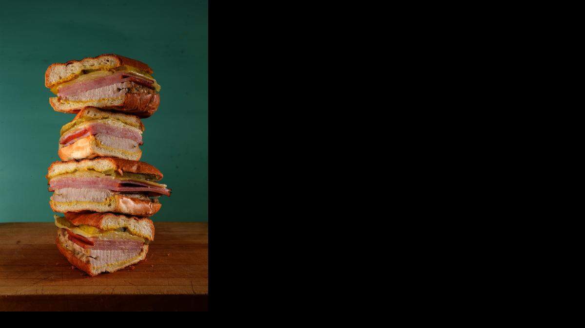 
Tower of power: A traditional Cuban sandwich calls for sliced ham and roast pork with a citrusy marinade and Swiss cheese, pickles and mustard, layered in Cuban bread.
