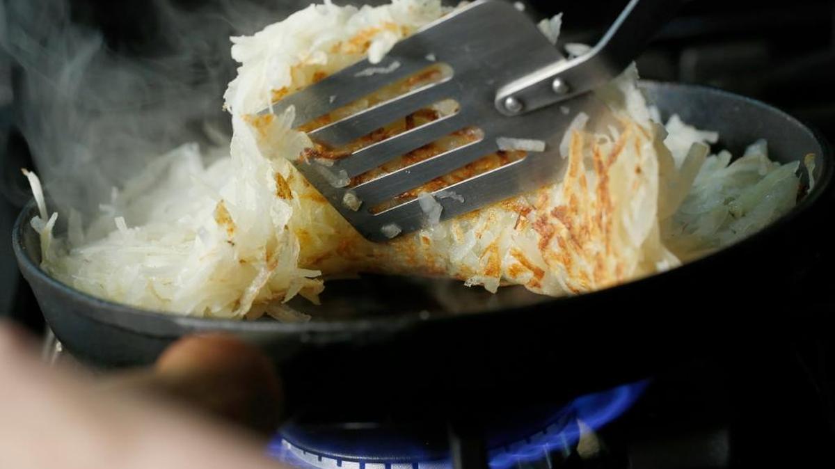 Add enough grated potatoes to the skillet that you can press them into a circle covering the whole pan. Cook them over medium low heat until the bottom is golden brown and crispy, then flip to crisp the other side.