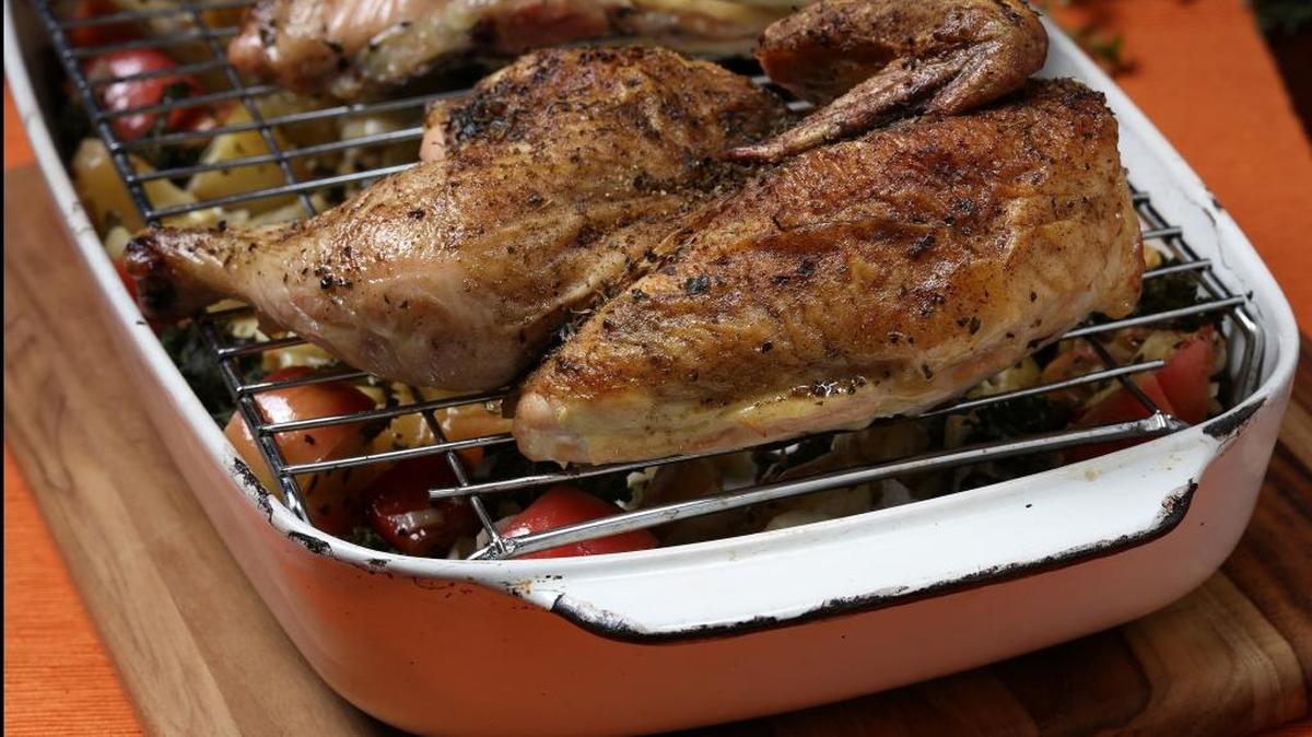 The chicken halves roast on a rack over the vegetables, ensuring crisp skin for the bird, and deeper flavor for the vegetables as the juices drip into them.