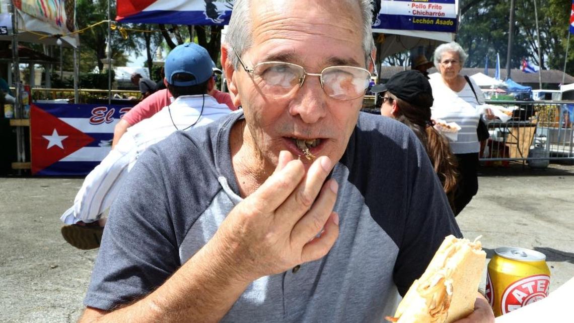 Gustavo Fernandez digs in to a pan con lechón at the 2015 Taste of Cuba festival at Hialeah Park.