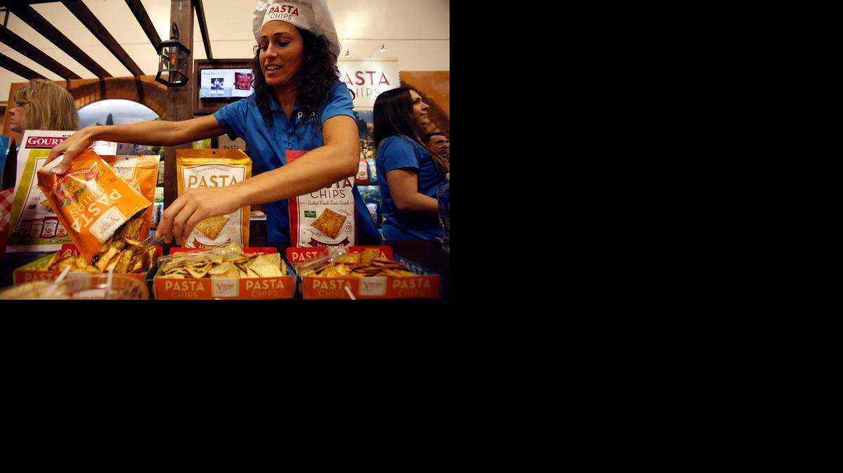 
New snack: Corintha Collins pours more Pasta Chips into a container at the Winter Fancy Food Show in San Francisco this month. 
