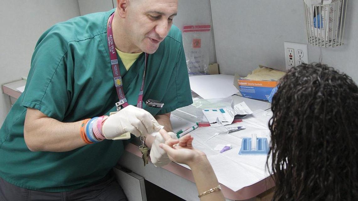 Clinical program manager, Alex Moreno, takes blood during a demonstration of teenage HIV testing. A UM team from the Miller School of Medicine reached out to teenagers during their health fair at Miami Jackson Senior High.