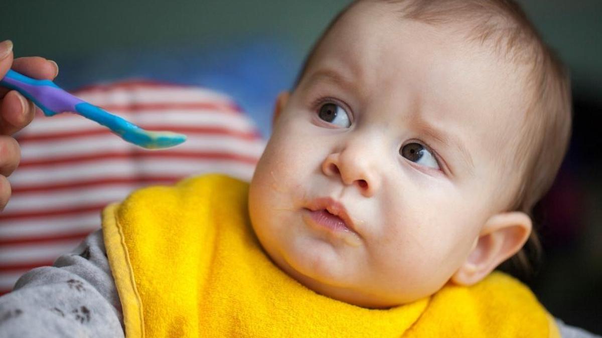 A 10-month-old baby boy eats his meal.