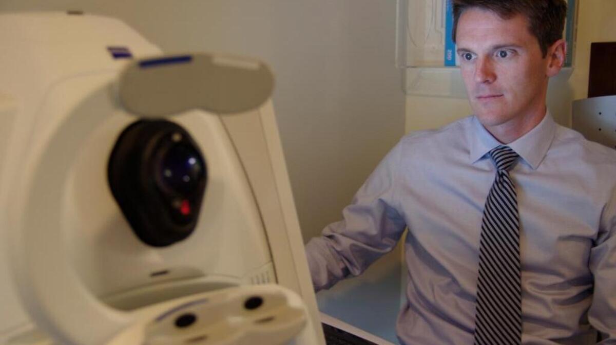 Dr. Justin Townsend reviews the results of a test that produces cross-section images of the retina at the University of Miami Bascom Palmer Eye Institute in Plantation.