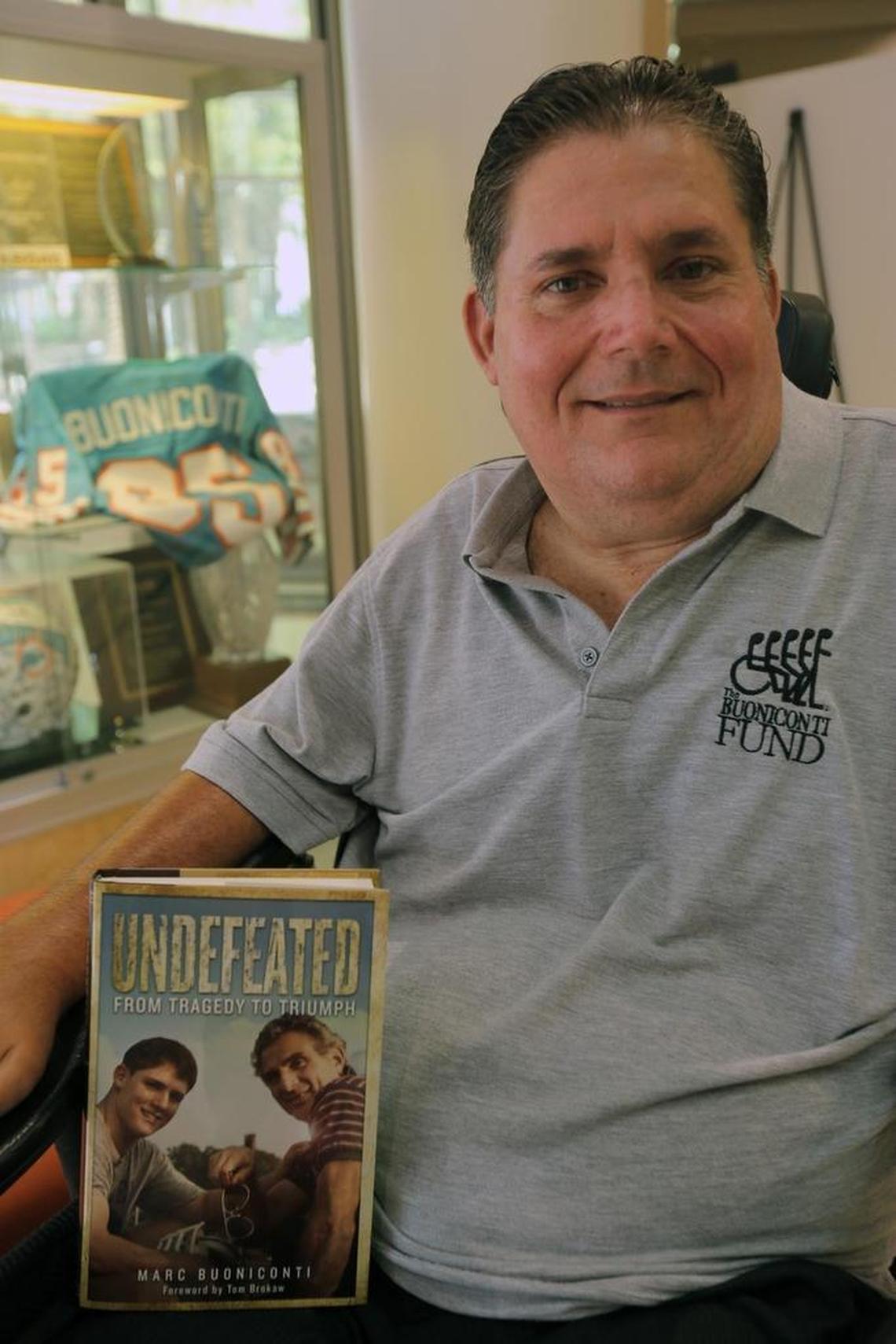 Marc Buoniconti, the football player for The Citadel who injured his spinal cord during a tackle and wound up paralyzed when he was 19, has co-written a book, “Undefeated: From Tragedy To Triumph.’’ Here he is in the lobby of The Miami Project to Cure Paralysis at the University of Miami campus, Sept. 14, 2017. His father’s Miami Dolphins jersey is in background.