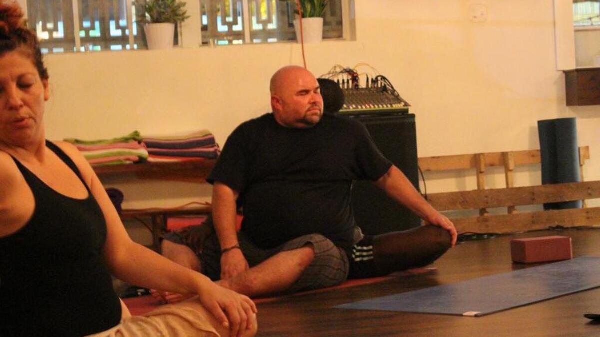Michael Swan,42, takes a deep stretch while holding on to his partner at Inhale Miami a yoga studio in Little Haiti on October 8.