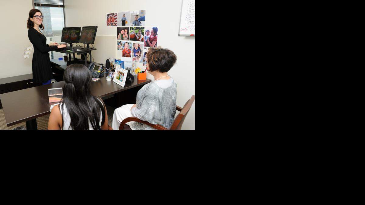 
STANDING DESK DEVOTEE: Marla Neufeld, with Greenspoon Marder Law, chats with coworkers. 
