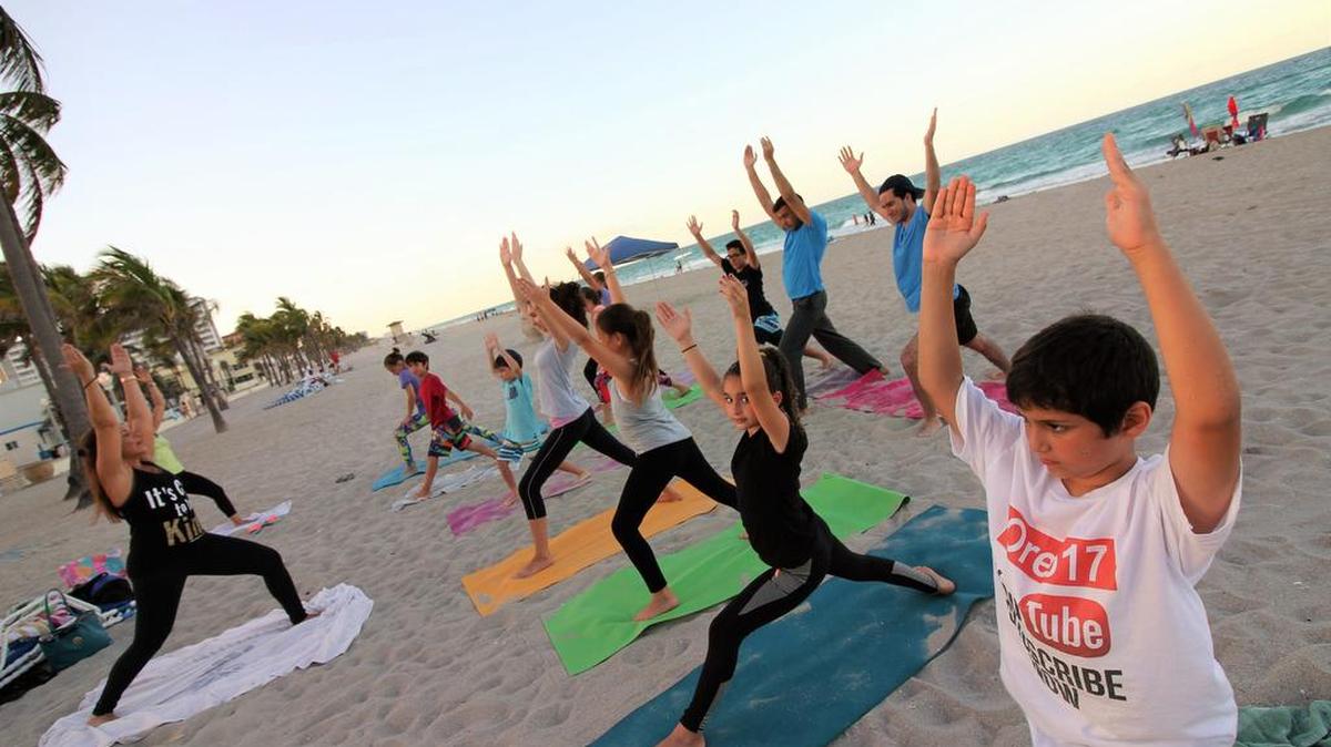 Kids and teens practice yoga at Miriam Amselem’s yoga class on Hollywood Beach. Studies have shown that yoga and mindfulness can improve concentration and help with anxiety