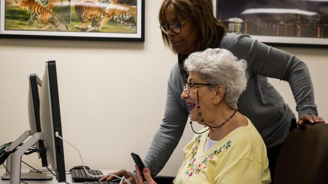 Evée Marie Miquel downloads her pictures with help from professor Joan Nurse at the Osher Lifelong Learning Institute at the University of Miami in Coral Gables.