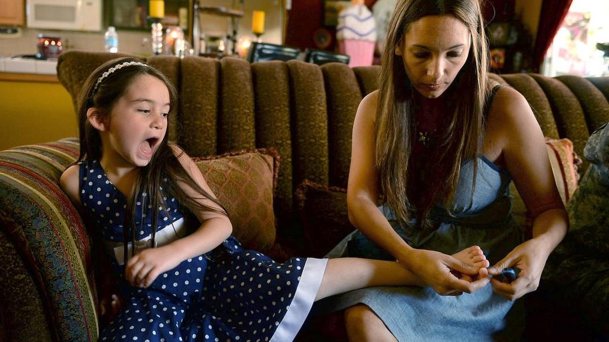At right, Shannon Briggs administers a blood sugar test to her daughter Lala Briggs, a 6-year-old from Clovis.