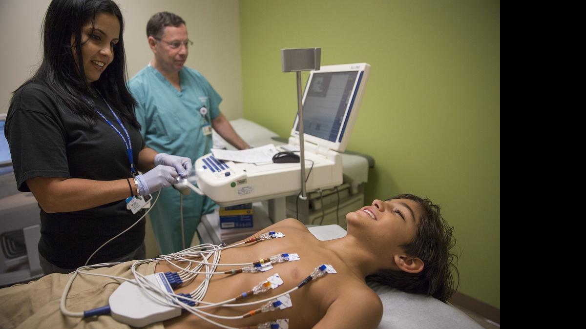 
PLUGGED IN: Zachary Pena, 11 is prepped for an EKG screening by EKG technician Jennifer Ayala and cardiologist Dr. Anthony Rossi at Nicklaus Children’s Hospital on July 13, 2015. EKGs can detect fatal defects in the heart that kill three out of 100,000 children annually. Pena’s mother Mabel felt strongly about having her son tested. Zachary plays baseball and basketball, and his family has a history of heart disease.
