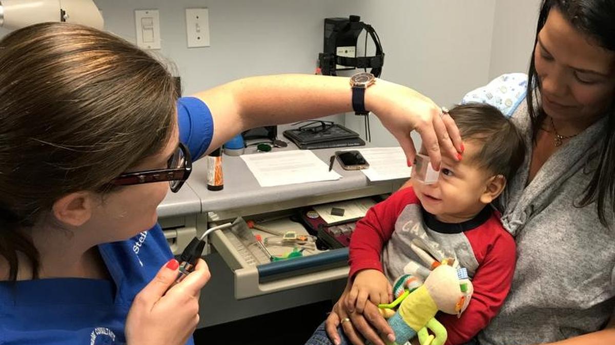 Pediatric ophthalmologist Dr. Tehilla Steiner examines 9-year-old Sebastian Guerrero, who is sitting on the lap of his mother, Kareline Garcia, in the Pediatric Ophthalmologists of South Florida’s office in Plantation.