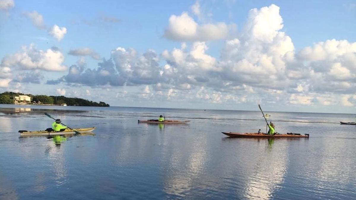 Kayakers, from left, Patrick Linfors, Adam Scholer and Eric Pino, as they arrive at Smathers Beach in Key West on Friday after a seven-day, 160-mile kayak trip from Miami to Key West as part of a Castaways Against Cancer fund-raising team.